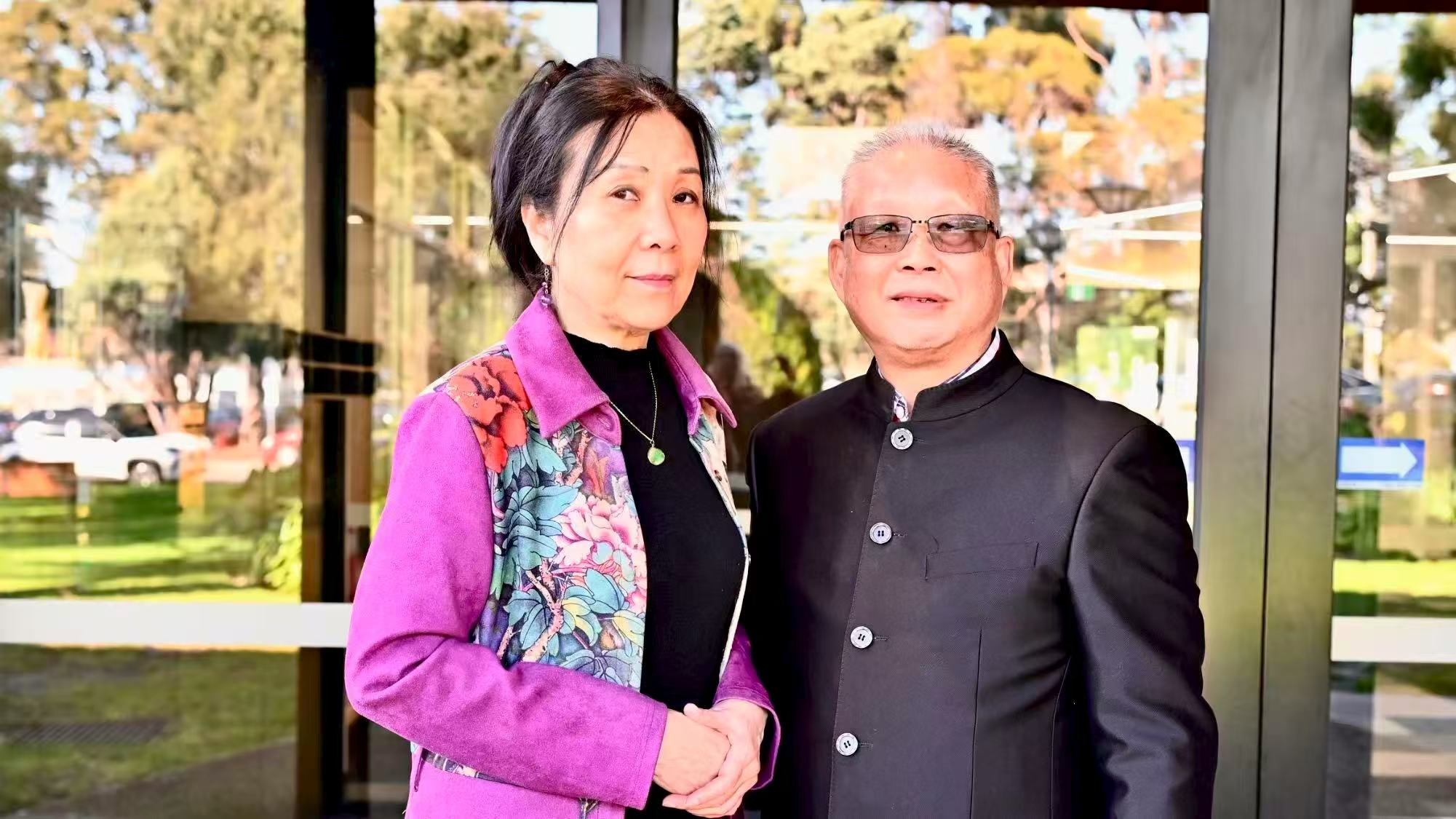 Two guests posing for a photograph beside the venue windows