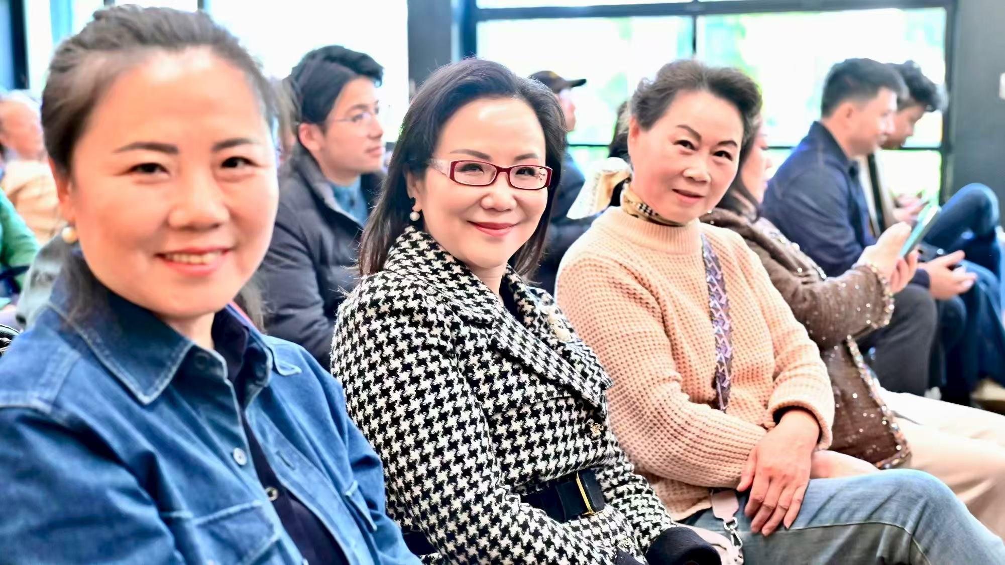 Several guests smiling for a photograph in the audience
